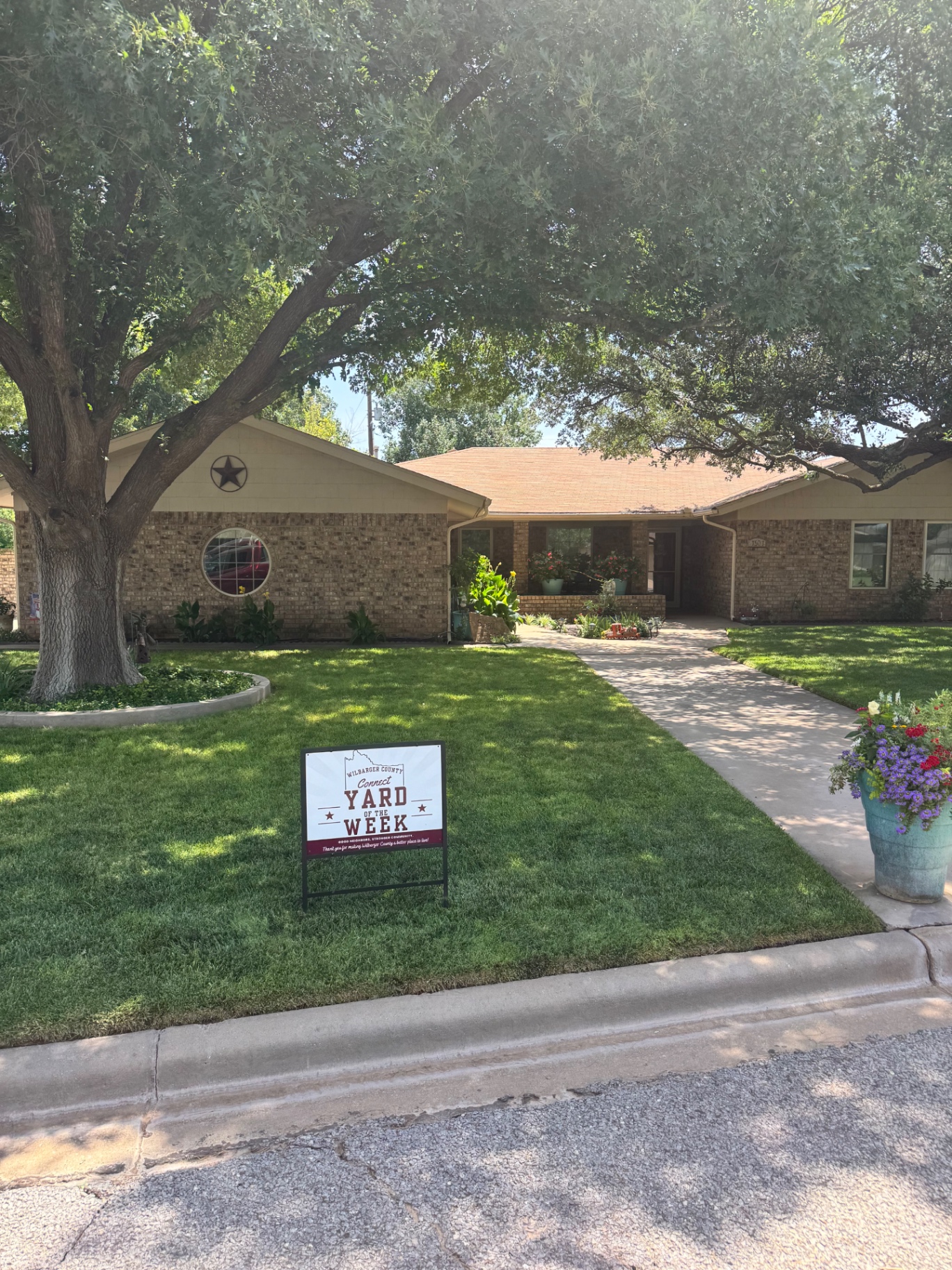 Yard of the Week sign in a lush green lawn in front of a brick home on Parker Drive in Vernon